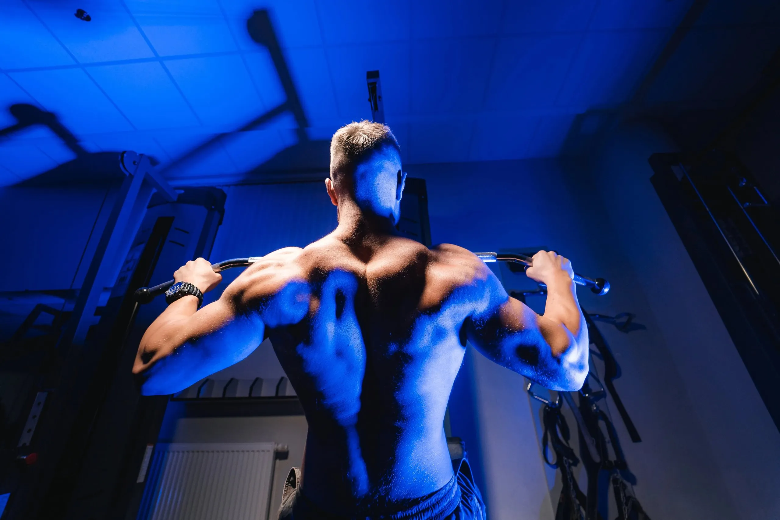 A man in a blue gym with a blue light background.