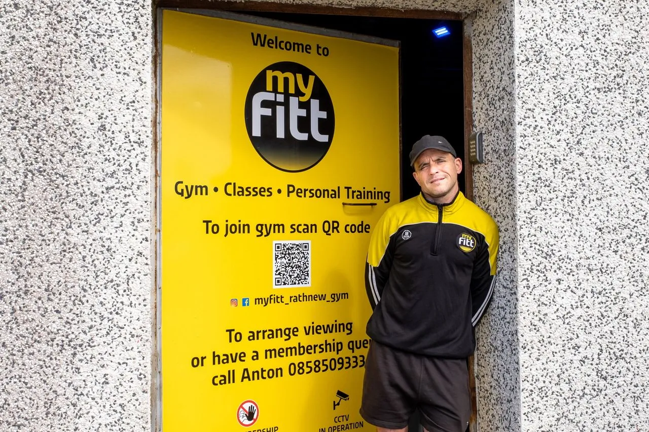 The owner at the door of the Myfitt Rathnew gym, beside the yellow welcome sign.
